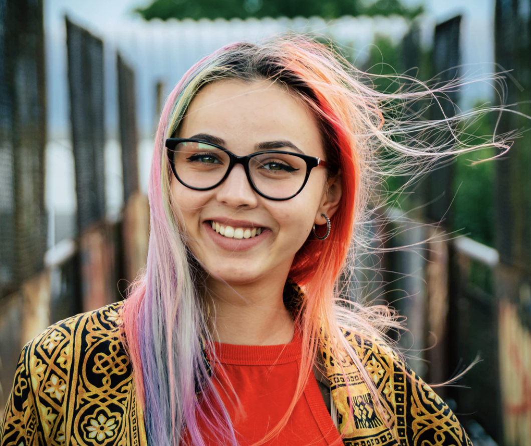 a young girl with colored hair and glasses